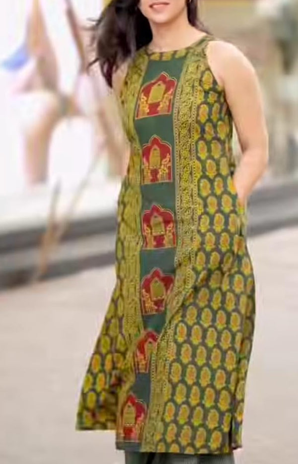 Woman wearing a green and red patterned kurta with a blurred indoor background