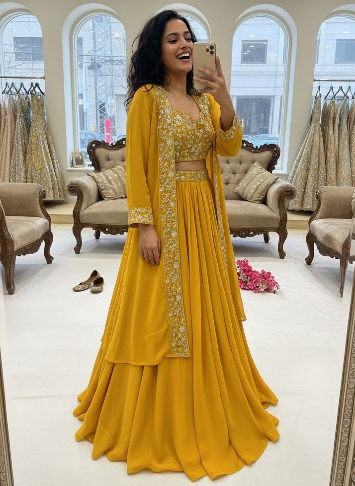 Woman in a yellow traditional outfit taking a mirror selfie in a store.