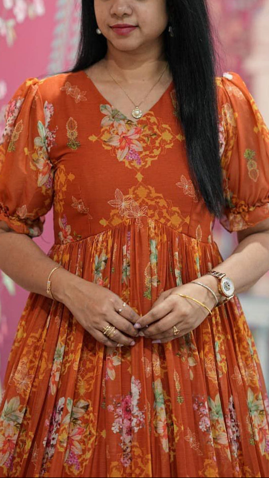 Woman wearing an orange floral dress against a pink floral background