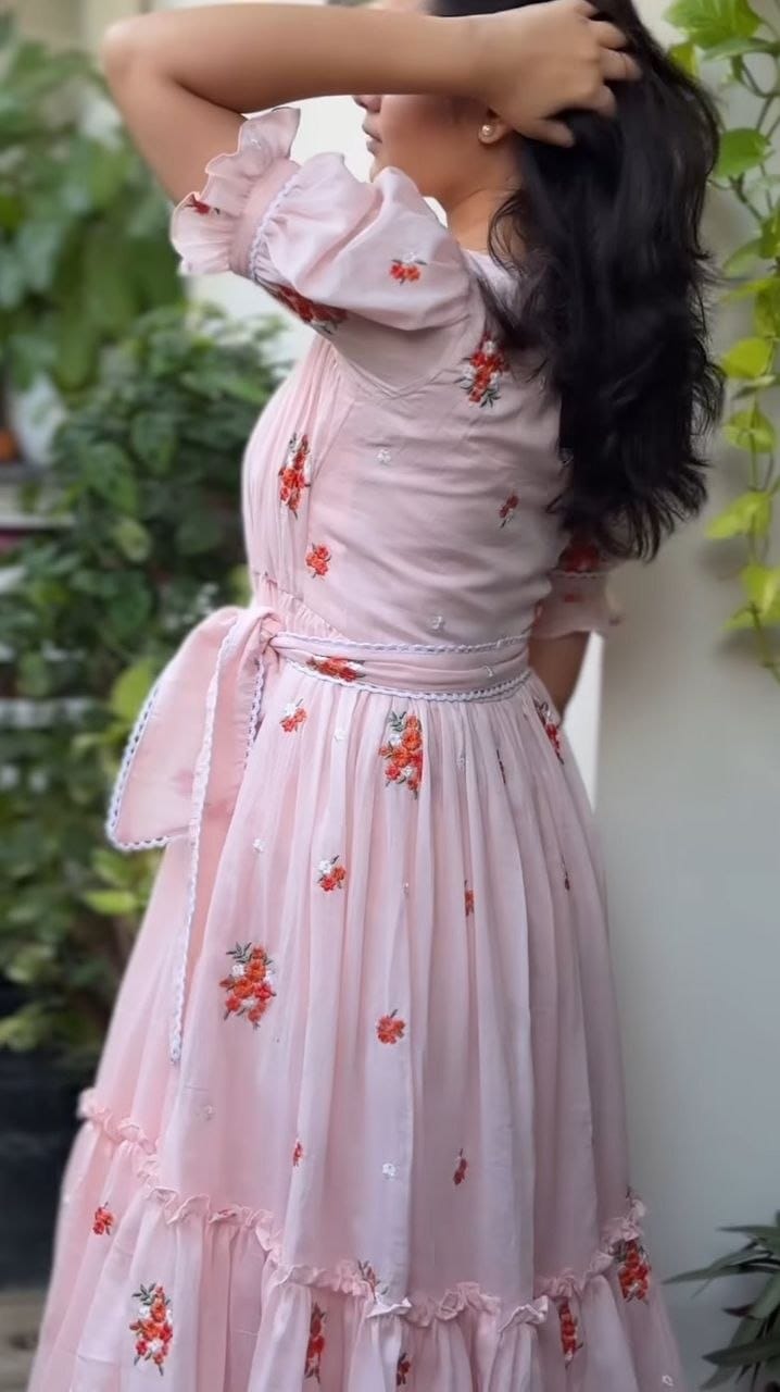 Woman wearing a pink floral dress with a blurred background